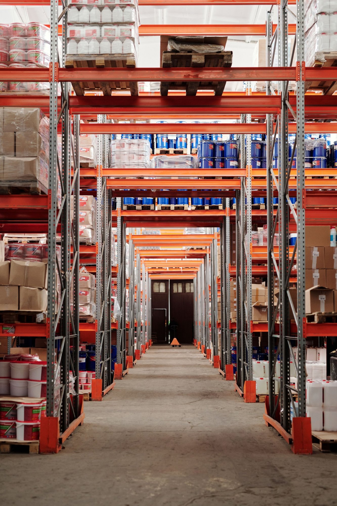 Pasillo de depósito con racks naranjas y pallets